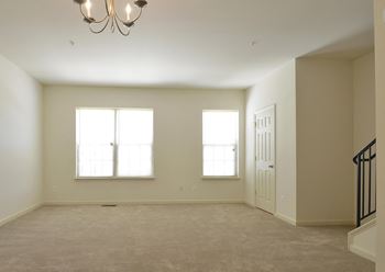 Empty room with a chandelier and two windows
